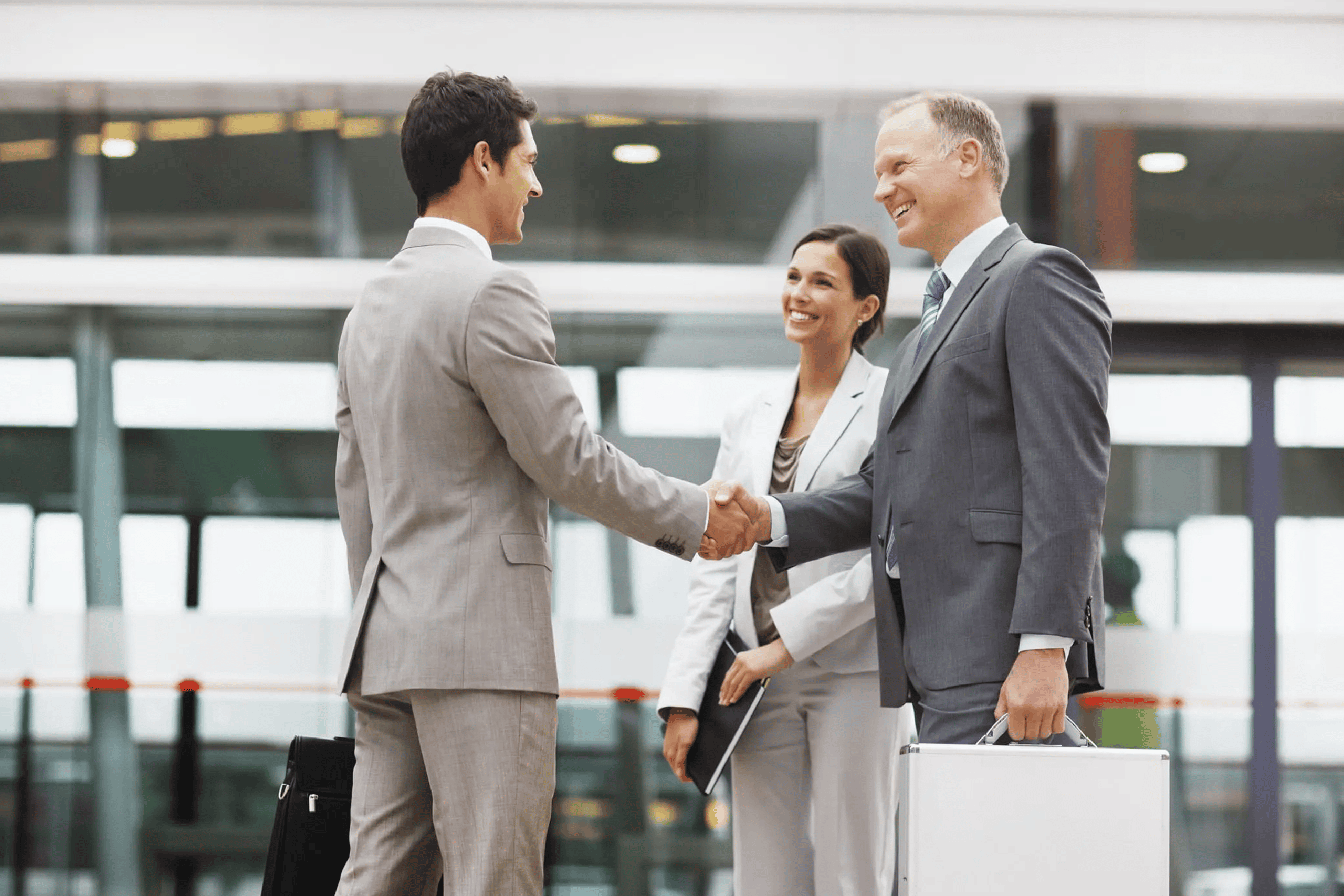 Businesspeople shaking hands at the airport.