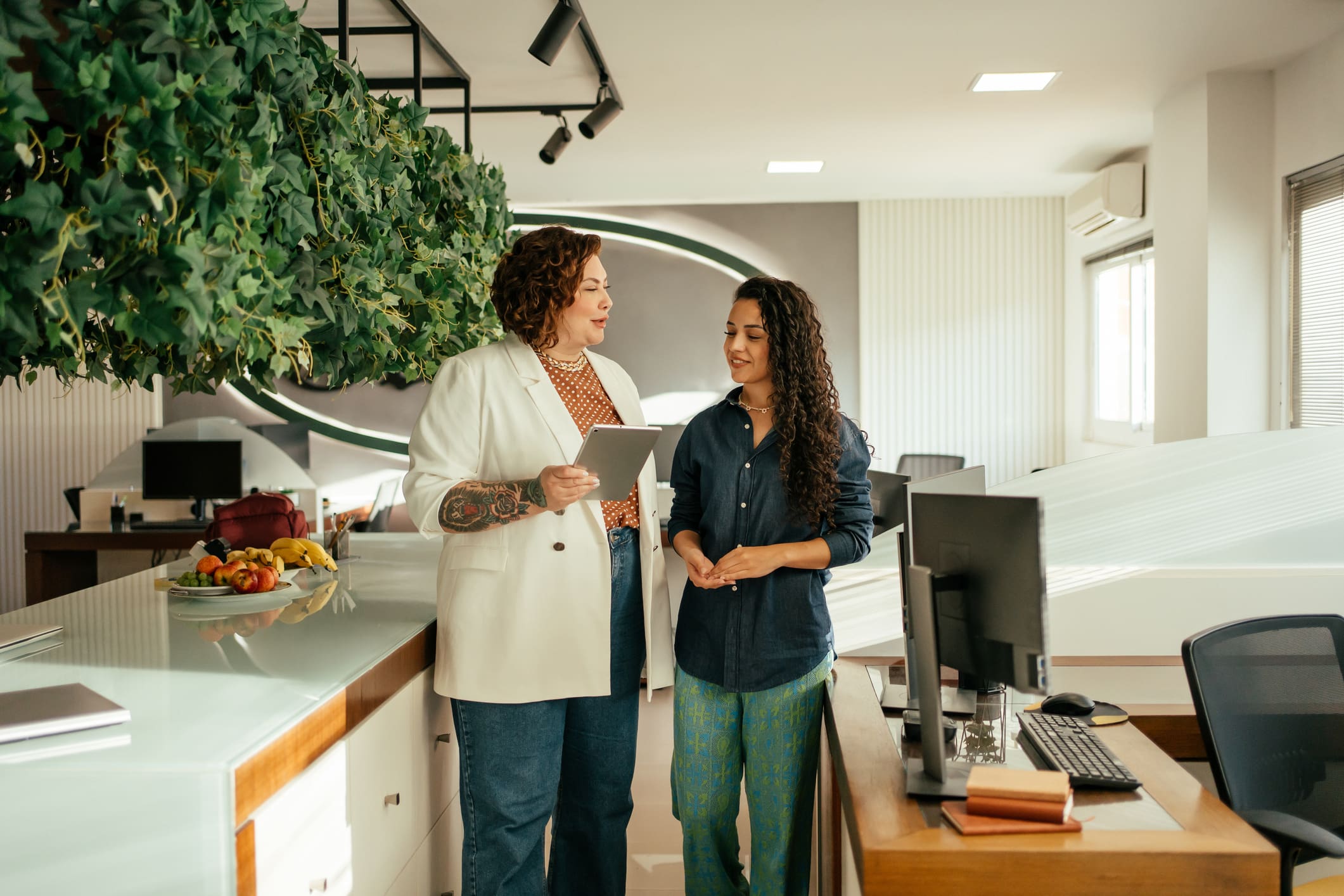 Two women discussing in a modern office.