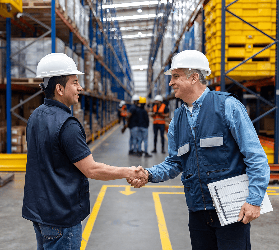 Two men in safety helmets greeting