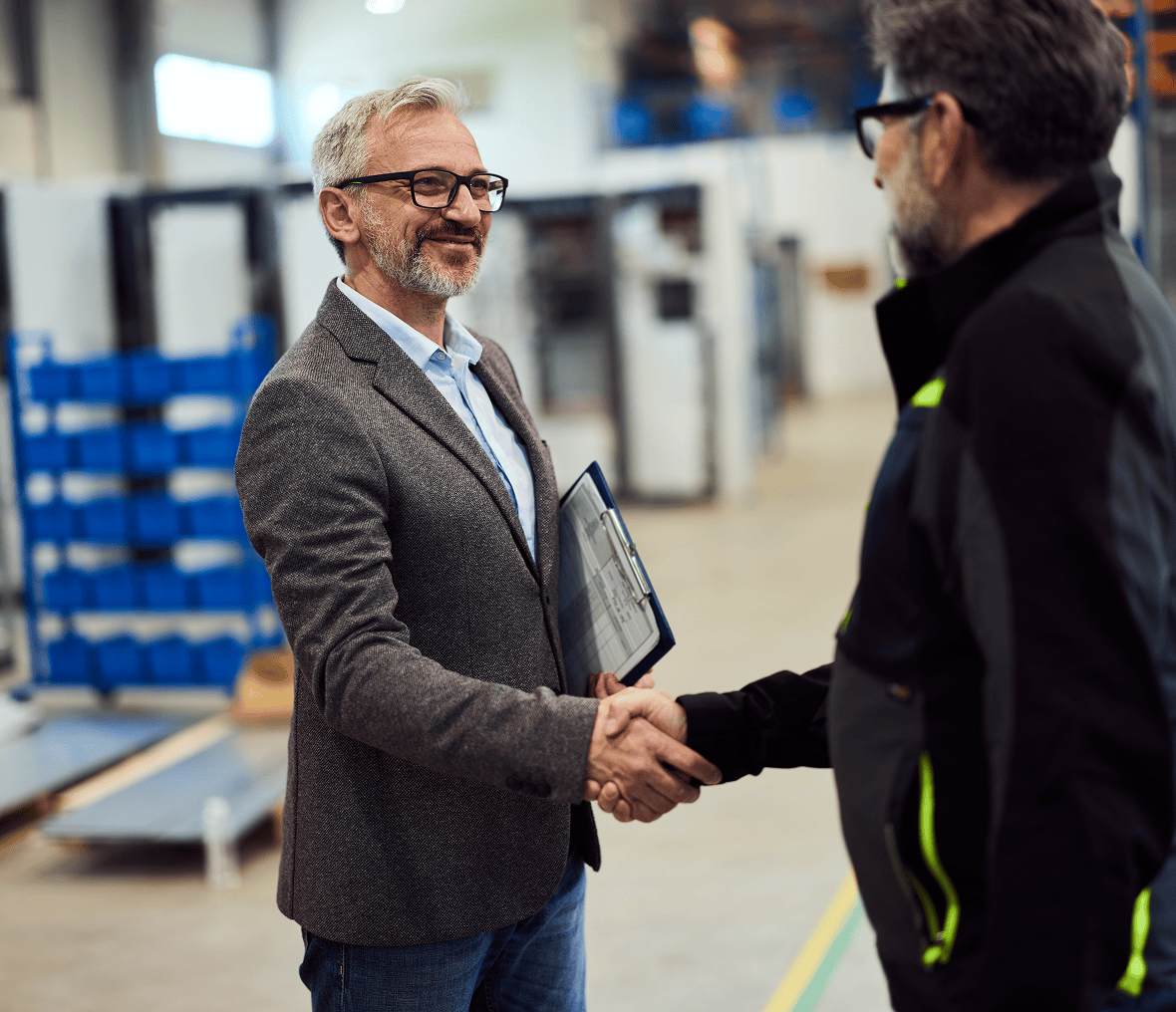 Two men greeting in a factory setting
